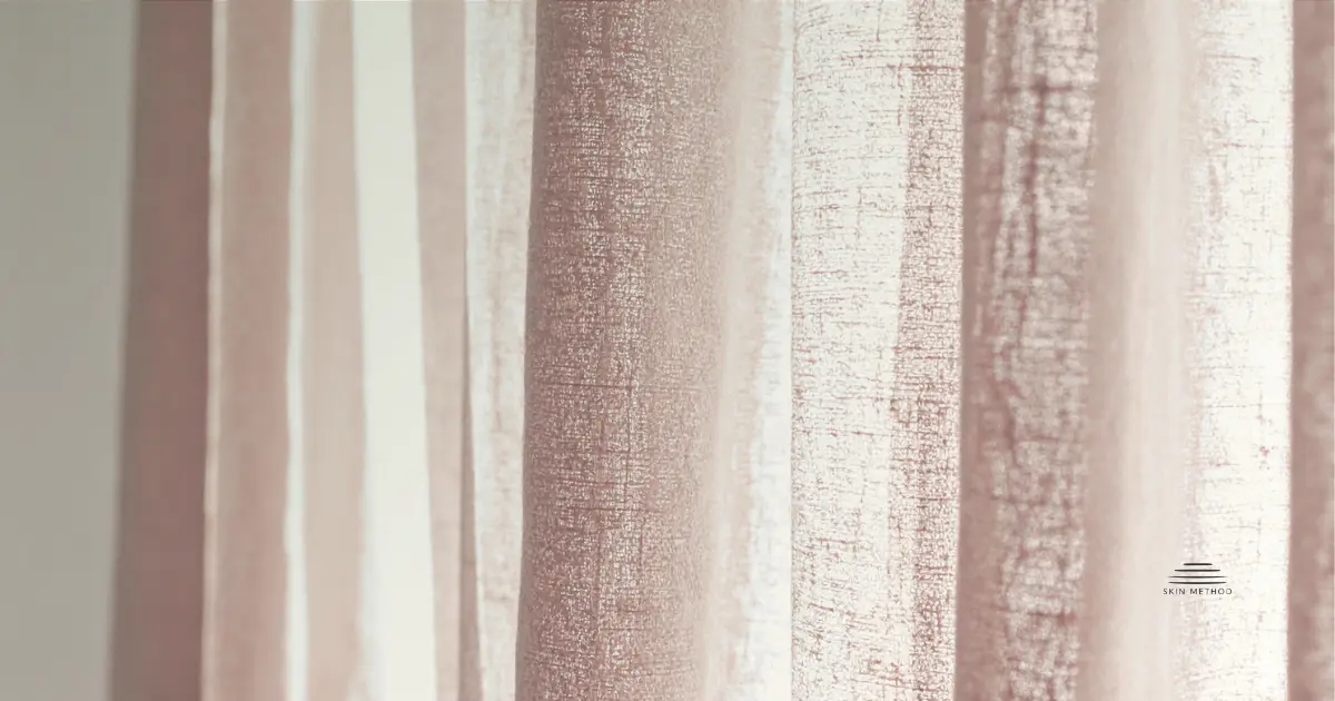 Soft linen curtains illuminated by warm natural light, showing gentle folds and natural fabric texture.