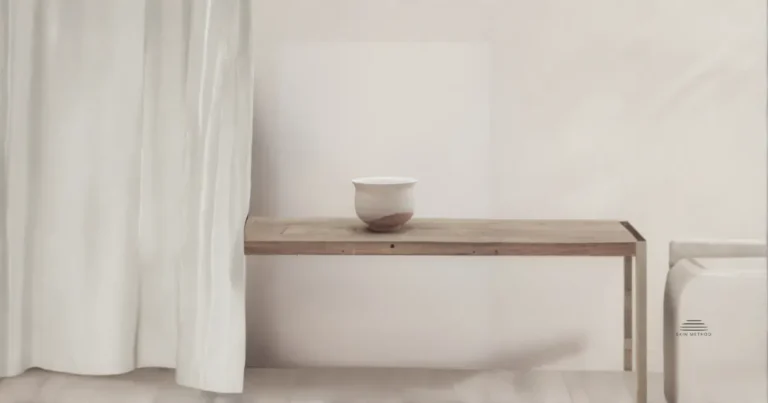 A single ceramic vessel resting on a wooden bench beside a soft linen curtain in natural light.