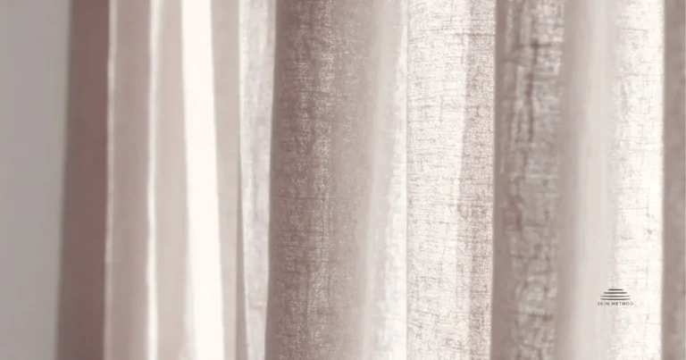 Soft linen curtains illuminated by warm natural light, showing gentle folds and natural fabric texture.