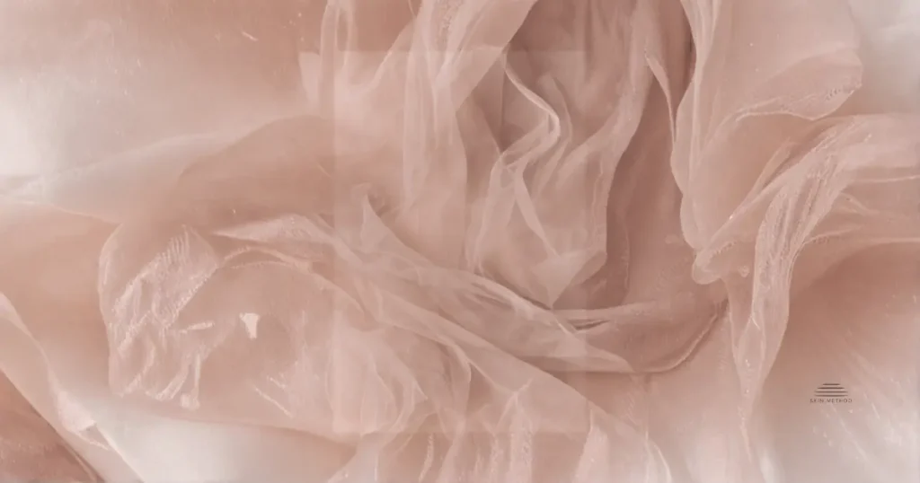 Layers of soft translucent fabric overlapping in muted peach tones.